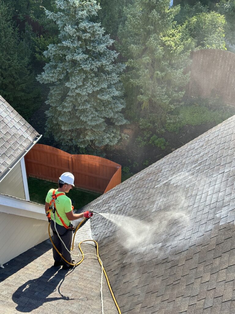 man spraying roofmaxx product on a roof